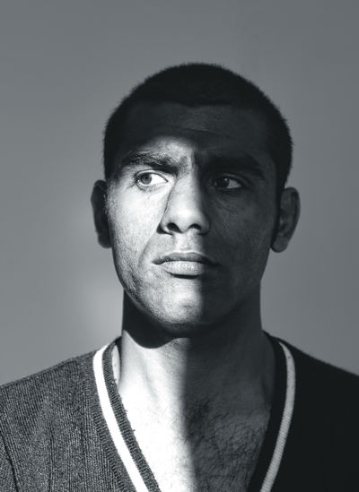 Close-up portrait of smiling young man against gray background