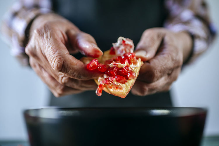 Man's hands peeling a pomegranate, close-up