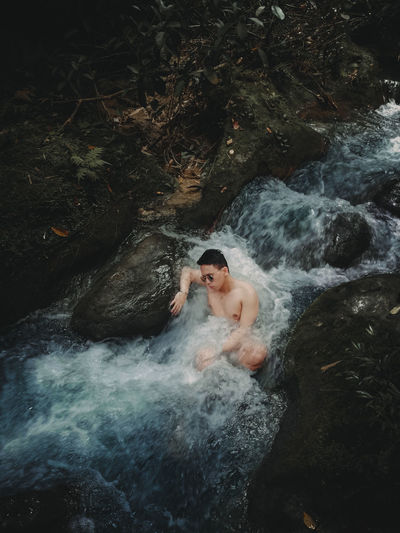High angle view of shirtless man in water