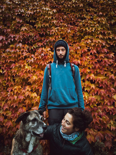 Portrait of family with dog on autumn leaves
