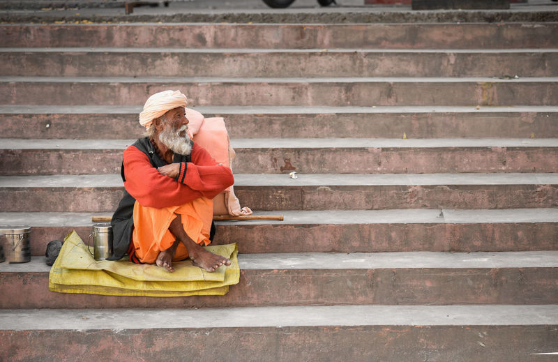 Homeless senior man sitting on steps 