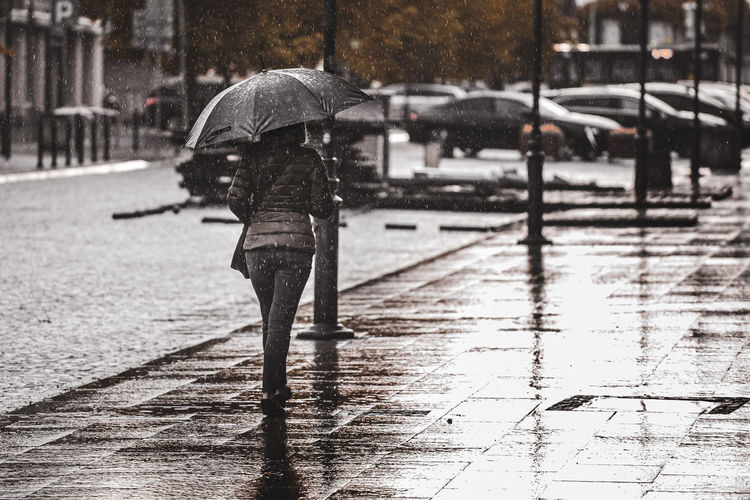 Man walking on wet street during rainy season