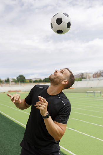 Active sportsman playing with soccer ball