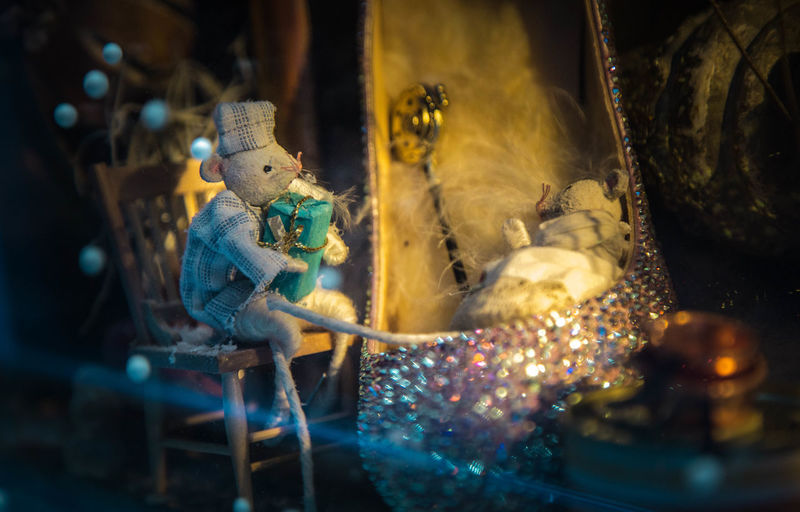 Close-up of toy mouse with gift box by stiletto
