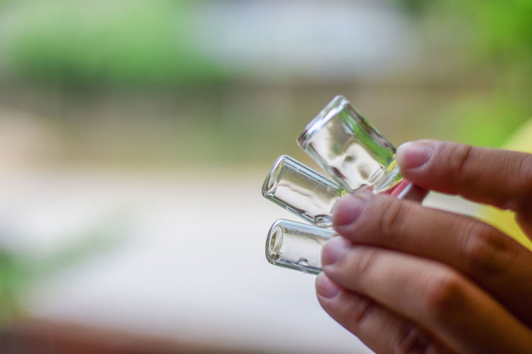Close-up of hand holding glass against blurred background