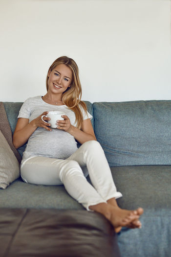 Woman sitting on sofa at home