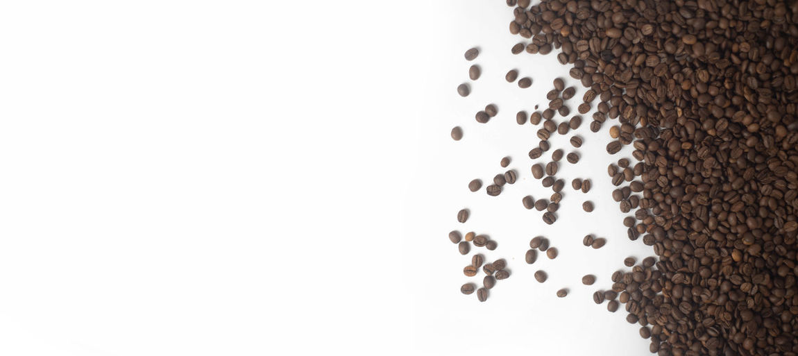 High angle view of coffee beans against white background