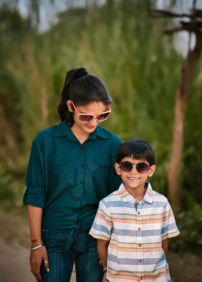 Mother and son wearing sunglasses standing outdoors