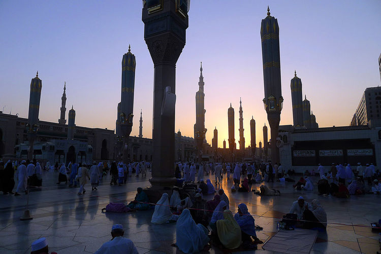Panoramic view of crowd in city at sunset
