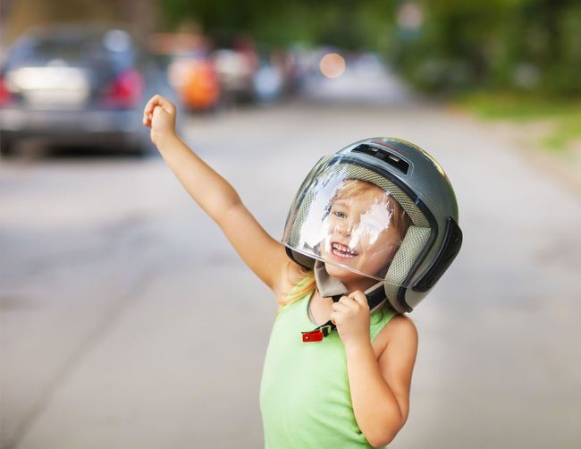 Cheerful girl wearing helmet outdoors