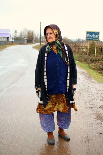 Full length of woman looking away while standing on road