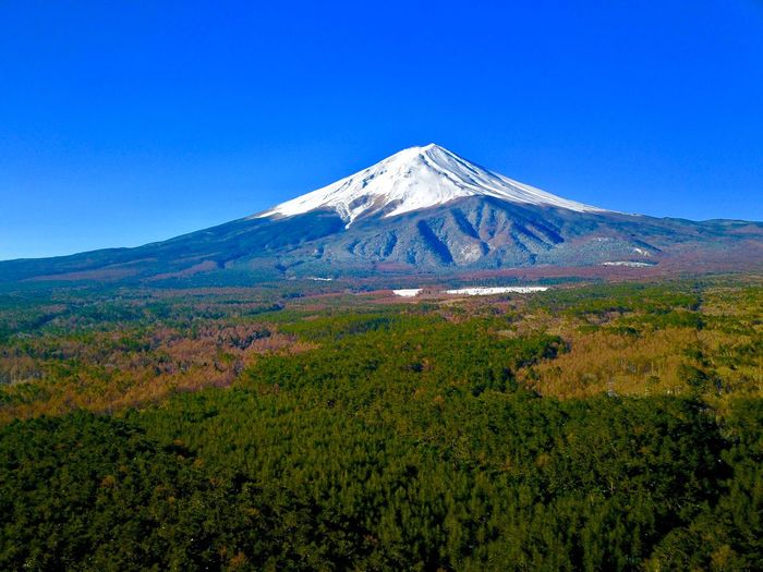 Scenic view of snowcapped mountains against blue sky, mt. fuji