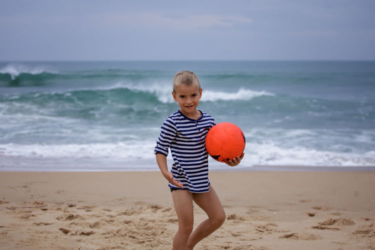Boy playing with ball at beach