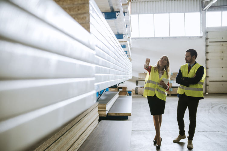 Man and woman in warehouse supervising stock