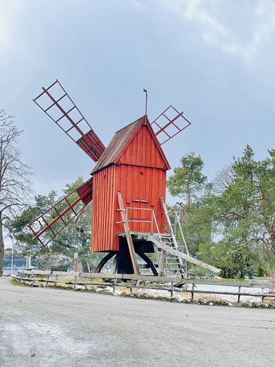 An old red weathered wooden windmill in the skansen open-air museum.