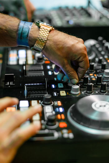 Cropped hands of people mixing music