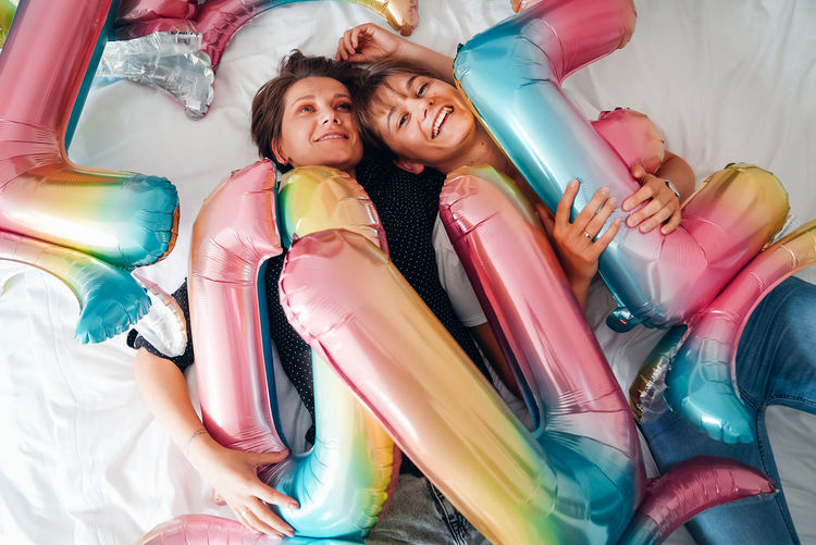 Photo session on a bed with colorful balloons saying love.