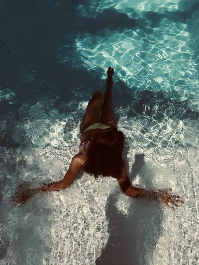 High angle view of woman relaxing in swimming pool