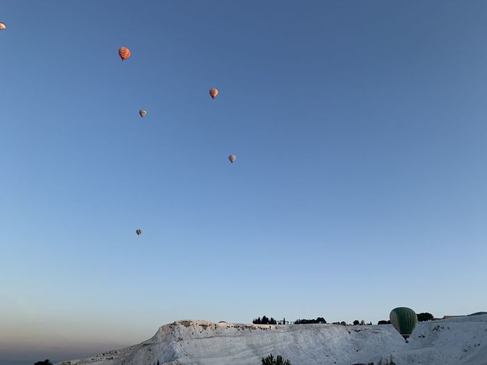 Low angle view of hot air balloons against sky in pamukkale
