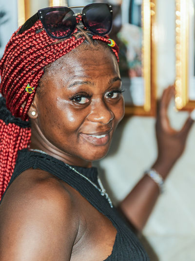 African woman smiling and showing something hanging on a wall in accra ghana