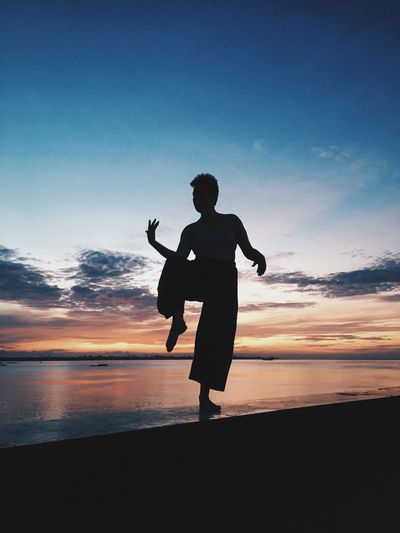 Full length of silhouette woman on beach at sunset