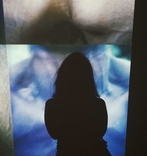Close-up portrait of silhouette people standing against window