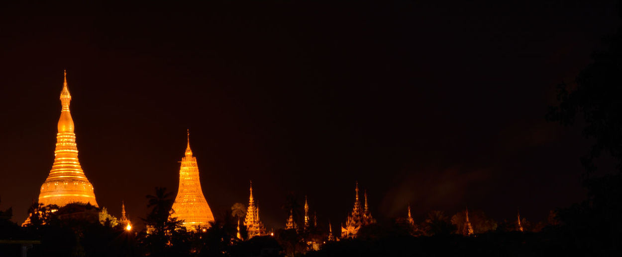 Panoramic view of illuminated temple building against sky at night