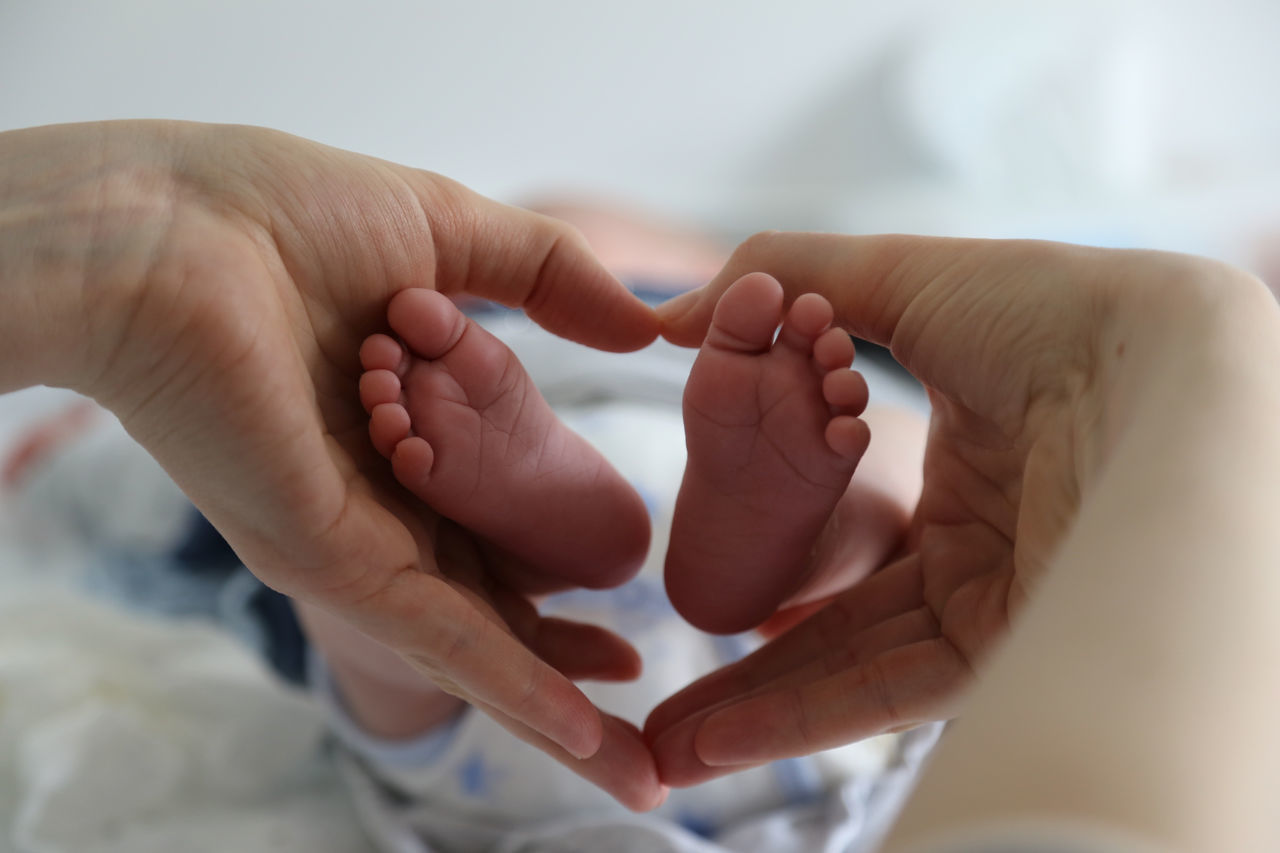 CLOSE-UP OF HANDS HOLDING BABY