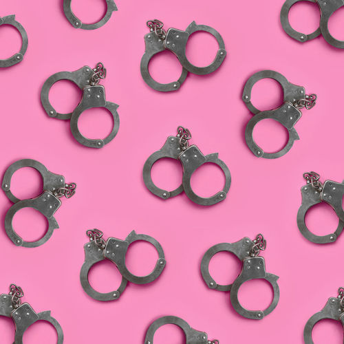 Full frame shot of handcuffs on pink table