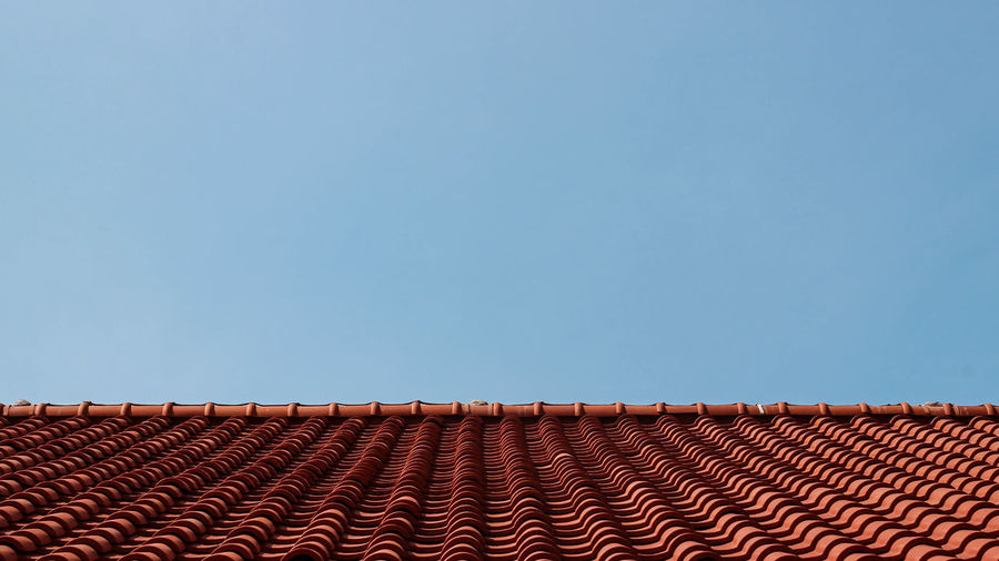 Low angle view of building roof against clear sky