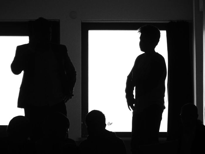 Silhouette businessman with male colleague in office during presentation