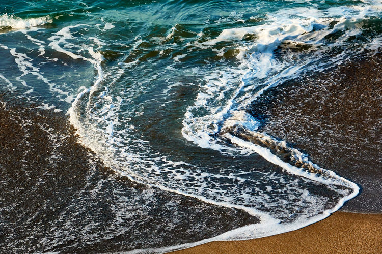 High angle view of waves splashing on shore