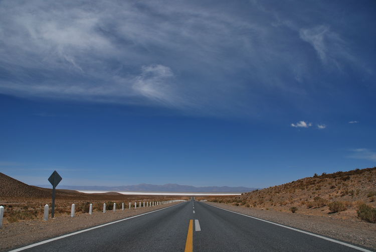 Road towards salinas grandes, jujuy, argentina, against clear blue sky 