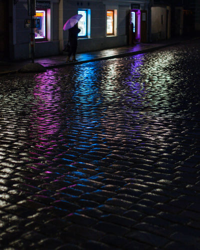 Reflection of woman walking in illuminated building
