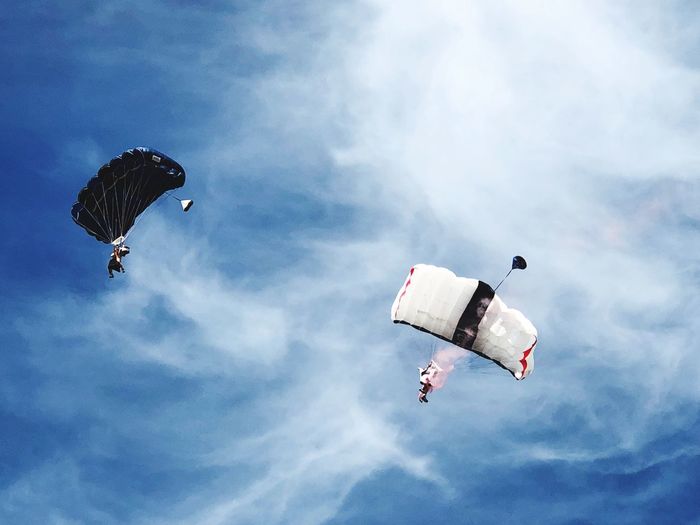 Low angle view of people paragliding