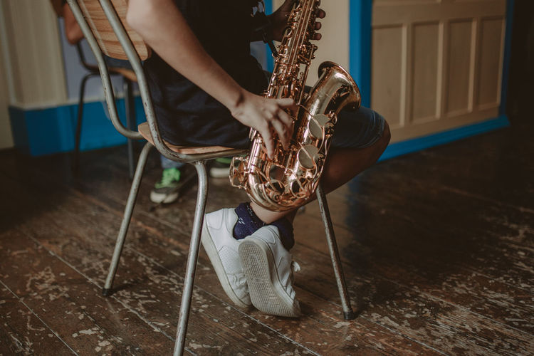 Low section of man playing saxophone