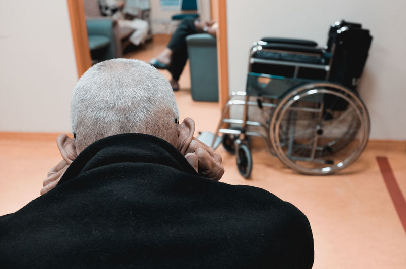 Rear view of senior man sitting in hospital