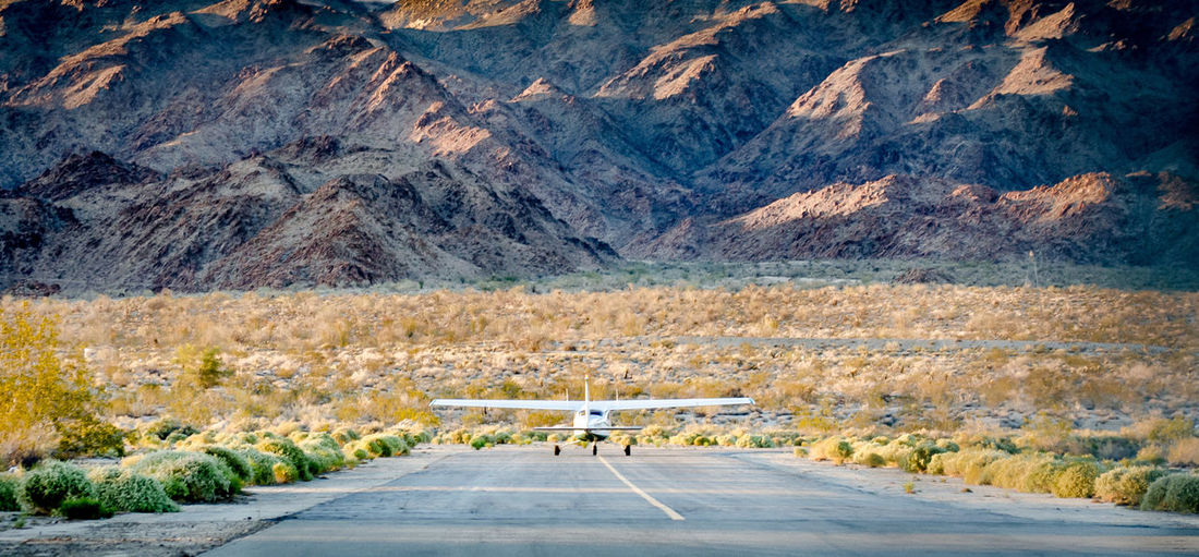 Airplane on airport runway by mountains