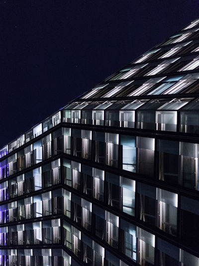 Modern office building against sky at night