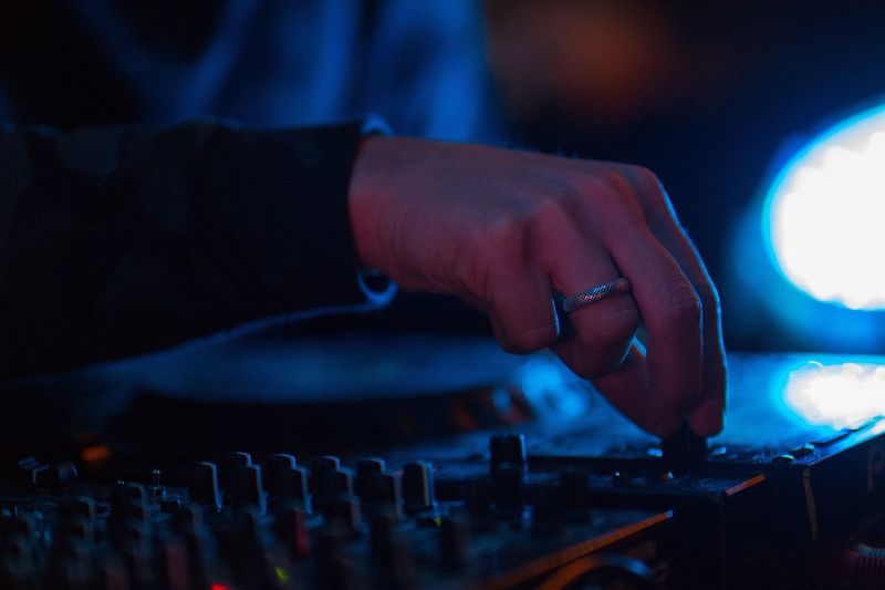 Cropped hand of male dj playing music at nightclub