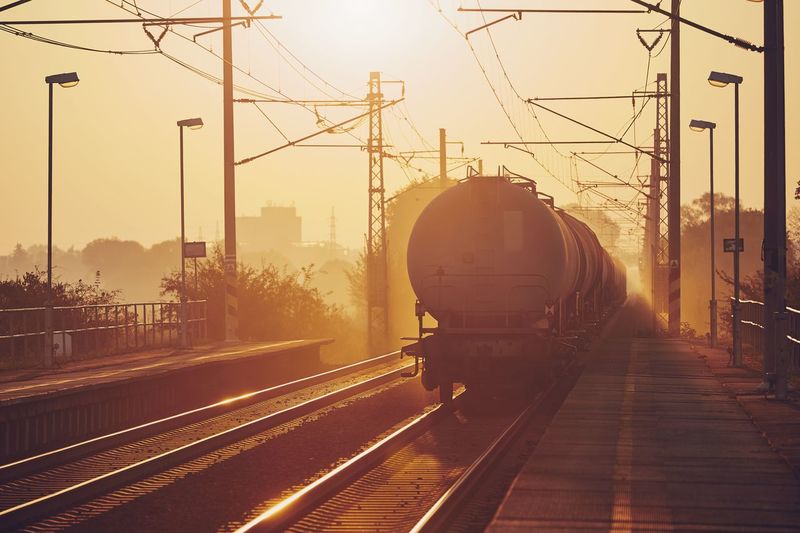 Freight train at railroad station during sunset