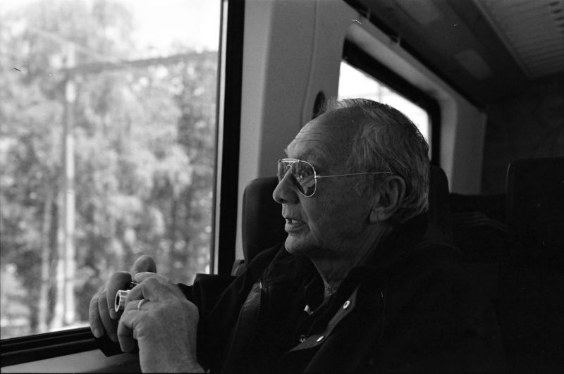 Senior man looking through window while sitting in bus