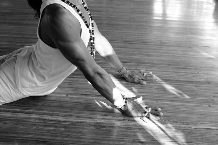 Midsection of man performing yoga in studio