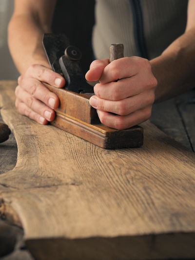 Cropped hands of carpenter working in workshop