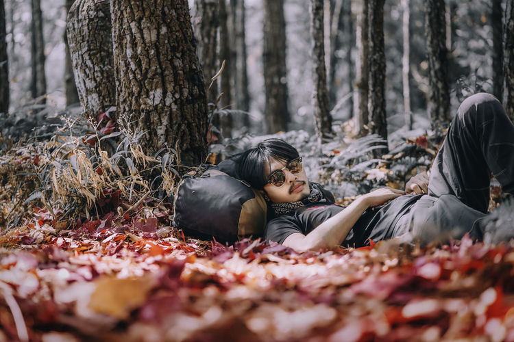 Man lying down in forest during autumn