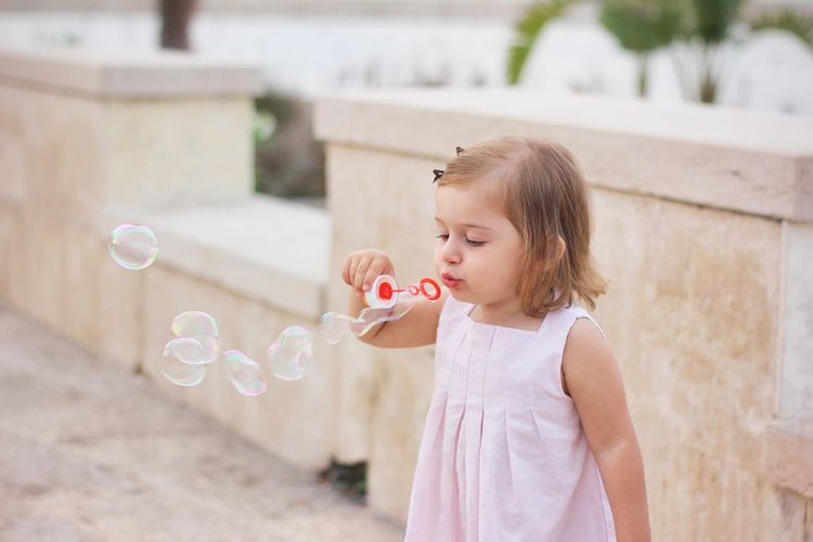 Girl blowing bubble from wand