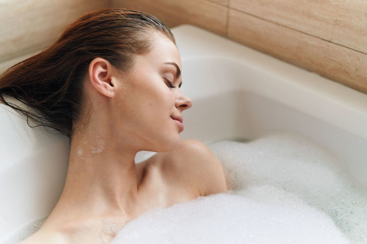 Close-up of woman relaxing in bathtub