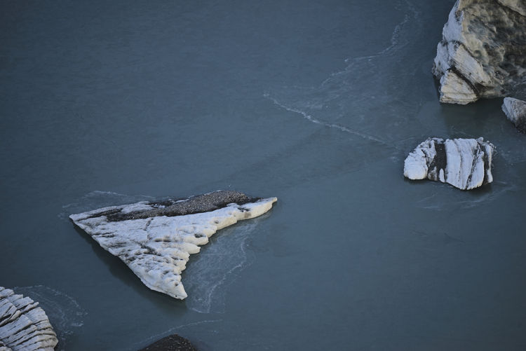 High angle view of rocks in sea during winter