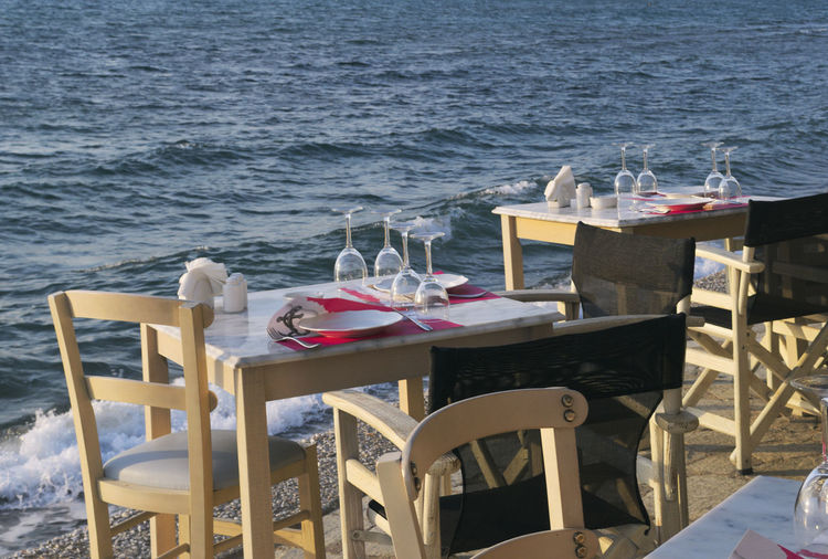 Chairs and tables at restaurant by sea