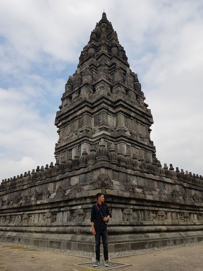 Full length of man standing outside temple against sky
